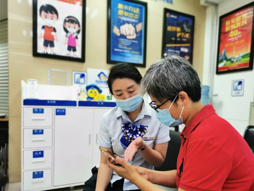 建行成都第六支行，大堂經(jīng)理為客戶介紹手機(jī)銀行&ldquo;大字&rdquo;模式